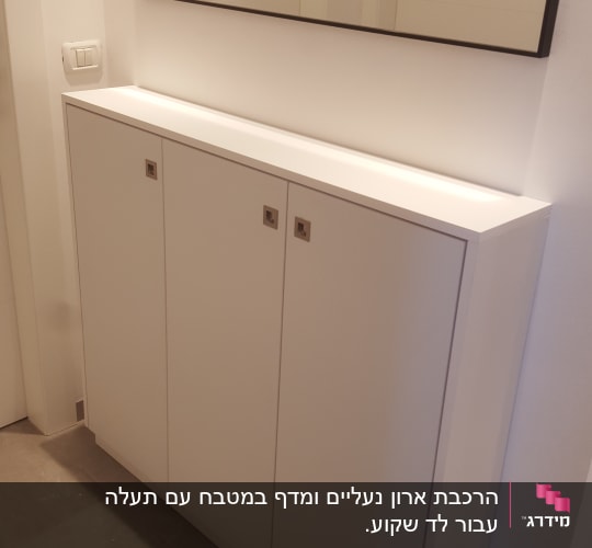 ארון עץ לבן עם שלוש דלתות ומראה מעל